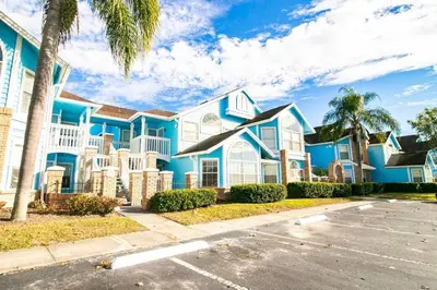 a blue house with a palm tree in front of it at 10 minutes to all Disney parks with pool and wifi in Kissimmee