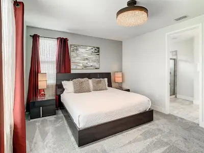 a bedroom with a bed and red curtains at 160 Minton Loop in Orlando