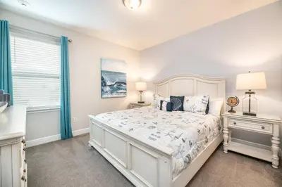 a bedroom with a white bed and a window at 7484 Marker Avenue in Orlando