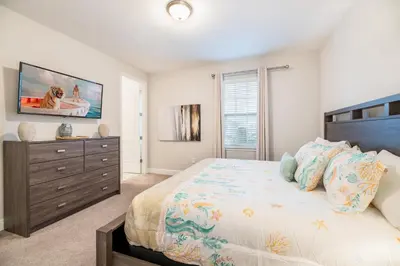 a bedroom with a large bed and a dresser at 7484 Marker Avenue in Orlando
