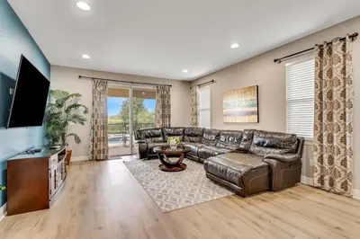 a living room with a leather couch and a flat screen tv at 7668 Wilmington Loop in Orlando