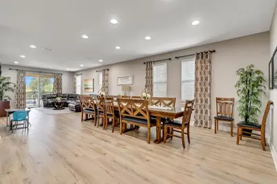 a dining room and living room with a table and chairs at 7668 Wilmington Loop in Orlando