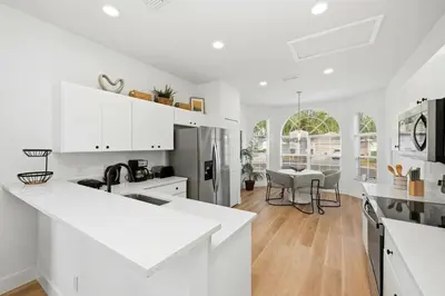 a kitchen with white cabinets and a dining room at Freshly Updated Near Disney Private Pool Resort in Kissimmee
