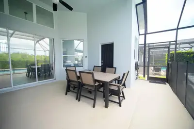 a dining room with a table and chairs on a balcony at 6BR Family Vacation Home near Disney in Kissimmee