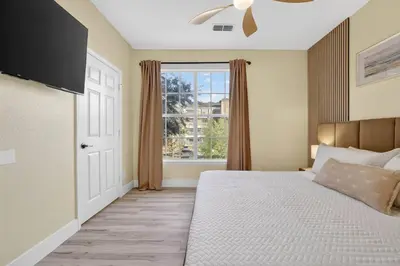 a bedroom with a large bed and a window at 3176-205 Resort Pool Condo Apt near Disney in Kissimmee