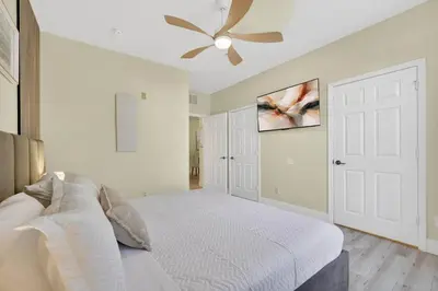 a bedroom with a white bed and a ceiling fan at 3176-205 Resort Pool Condo Apt near Disney in Kissimmee