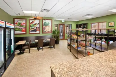 a library with green walls and tables and chairs at Townhouse 4Q c/ Piscina no Paradise Palms in Kissimmee