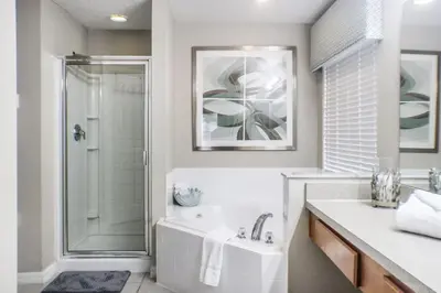 a bathroom with a tub and a shower and a sink at Family Private Home W Heated Pool 12Min To Walt Disney in Kissimmee