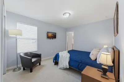 a bedroom with a bed and a desk and a chair at Savvy 4Bed Stay Near Orlando Attractions in Kissimmee