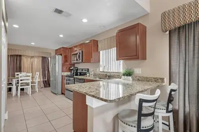 a kitchen with a counter and chairs in a room at Lakefront Home Game Room & Views in Kissimmee
