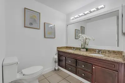 a bathroom with a toilet and a sink and a mirror at Lakefront Home Game Room & Views in Kissimmee