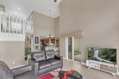 a living room with a couch and a flat screen tv at Lakefront Home Game Room & Views in Kissimmee