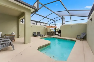 a swimming pool with a glass roof on a house at Townhome 4Q c/ Piscina Privativa no Storey Lake in Kissimmee