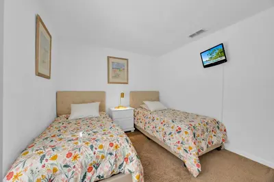 two beds in a room with white walls at Spacious Emerald Home with Pool Lanai Near Disney in Kissimmee