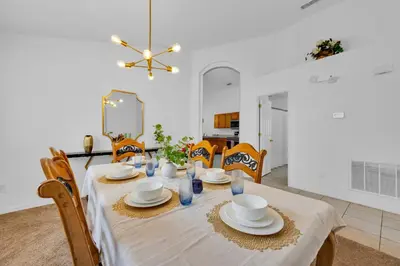 a dining room with a table with plates and dishes on it at Spacious Emerald Home with Pool Lanai Near Disney in Kissimmee