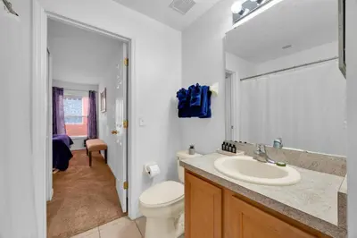 a white bathroom with a sink and a toilet at Spacious Emerald Home with Pool Lanai Near Disney in Kissimmee