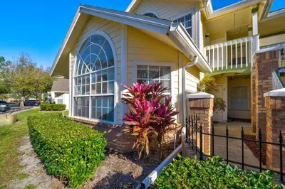 a house with a fence and a plant in front of it at Cozy Ground Floor Studio Near Disney in Kissimmee