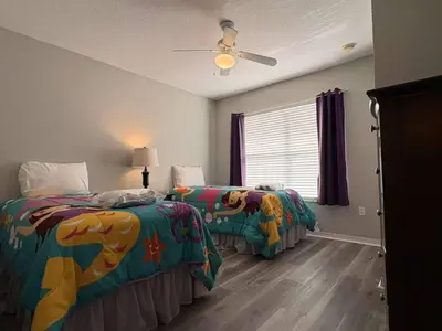 a bedroom with two beds and a window at 4 Bedroom 3 Bathroom Villas At Seven Dwarfs 24-101 in Kissimmee