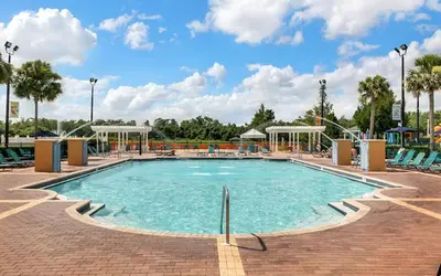 a pool at a resort with chairs and a playground at 4 Bedroom 3 Bathroom Villas At Seven Dwarfs 24-101 in Kissimmee