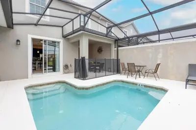 a swimming pool in a house with a table and chairs at 4BR Townhome w Pool in Storey Lake - Near Disney in Kissimmee
