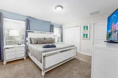 a bedroom with a bed and a television in it at 4BR Townhome w Pool in Storey Lake - Near Disney in Kissimmee