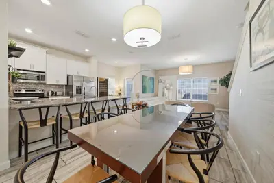a kitchen with a large island with bar stools at Cozy 5 Bedrooms and 4 Bathrooms At Storey Lake in Kissimmee