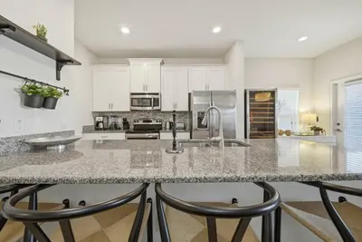 a kitchen with white cabinets and a granite counter top at Cozy 5 Bedrooms and 4 Bathrooms At Storey Lake in Kissimmee