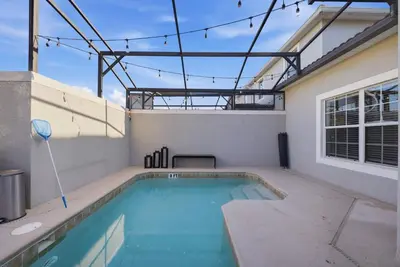 a swimming pool on the roof of a house at Cozy 5 Bedrooms and 4 Bathrooms At Storey Lake in Kissimmee