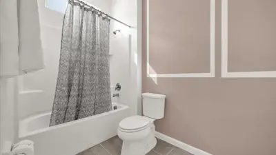 a white bathroom with a toilet and a shower curtain at Upstay Spacious Villa w Pool, Hot Tub & Game Room in Kissimmee