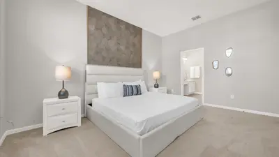 a white bedroom with a large white bed and lamps at Upstay Spacious Villa w Pool, Hot Tub & Game Room in Kissimmee