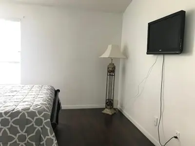 a bedroom with a bed and a flat screen tv on the wall at 10min to Disney parks new condo free wifi & pool in Kissimmee