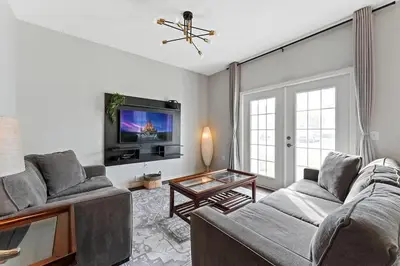 a living room with a couch and a tv at Townhome 4Q Temático — 15min da Disney in Kissimmee