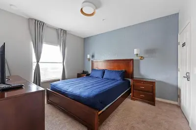 a bedroom with a bed and a desk and a computer at Townhome 4Q Temático — 15min da Disney in Kissimmee
