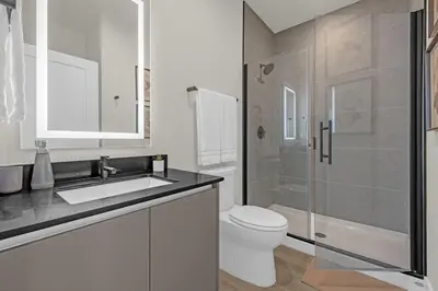 a bathroom with a toilet and a sink and a shower at Luxury 4 Bedroom Family Getaway w Private Pool in Orlando