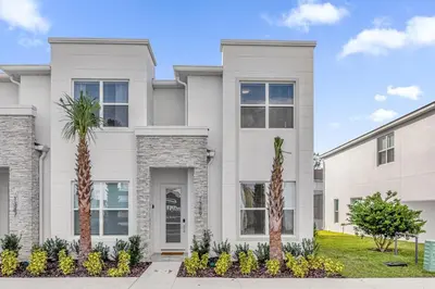 a white house with palm trees in front of it at Luxury 4 Bedroom Family Getaway w Private Pool in Orlando