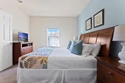 a bedroom with a large bed and a television at Townhome 4Q no West Lucaya — 15min Disney in Kissimmee