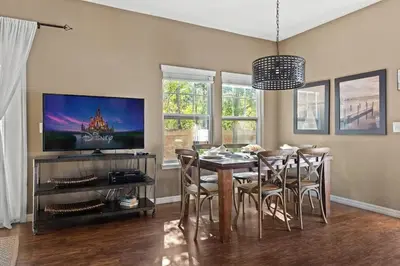 a dining room with a table and chairs and a television at Townhome 4Q no West Lucaya — 15min Disney in Kissimmee