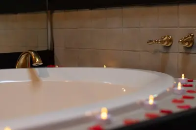 a bath tub with a faucet and candles in a bathroom at Romantic Getaway Cabin with Jacuzzi in Kissimmee