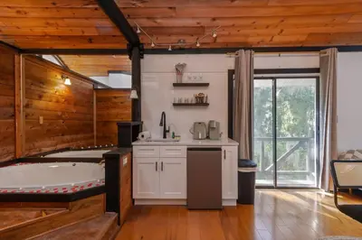 a kitchen with a bath tub and a large room at Romantic Getaway Cabin with Jacuzzi in Kissimmee