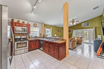 a kitchen with wooden cabinets and a stove top oven at The Art House Home for 8 in Orlando