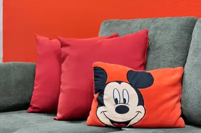 a pillow with a mickey mouse on a couch at Mickey Family Condo - 4 Miles to Disney in Orlando