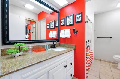 a bathroom with a sink and a red wall at Mickey Family Condo - 4 Miles to Disney in Orlando