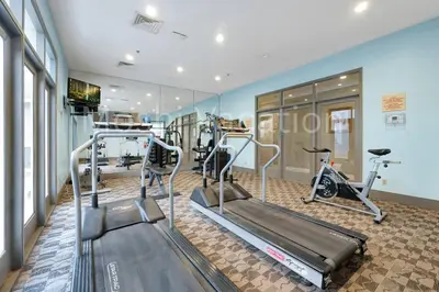 a gym with treadmills and ellipticals in a room at Mickey Family Condo - 4 Miles to Disney in Orlando