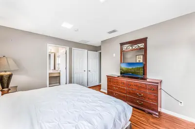 a bedroom with a bed and a tv on a dresser at Luxury 8-Bed Villa Near Disney With Pool & More in Kissimmee
