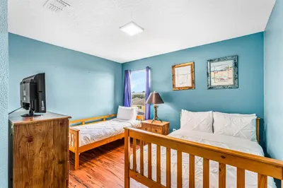 a living room with two beds and a tv at Luxury 8-Bed Villa Near Disney With Pool & More in Kissimmee