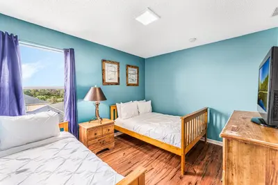 a bedroom with two beds and a tv and a window at Luxury 8-Bed Villa Near Disney With Pool & More in Kissimmee