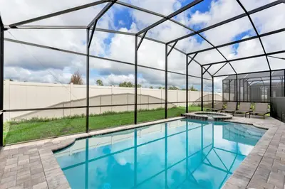 an indoor swimming pool with a glass roof and a swimming patio at Ev1810 - Solara Galaxy Villa in Orlando