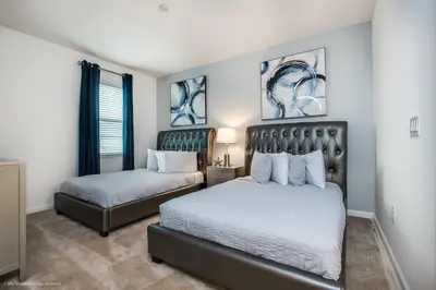 a bedroom with two beds and paintings on the wall at Ev2619 - Sonoma Retreat in Kissimmee