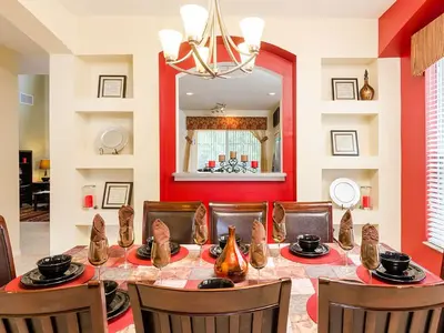a dining room with a table and chairs and a mirror at Ev2753 - Golden Horizon Villa in Kissimmee