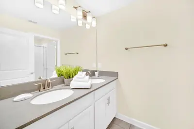 a bathroom with two sinks and a large mirror at Ev4829 - Lullaby Oasis in Kissimmee